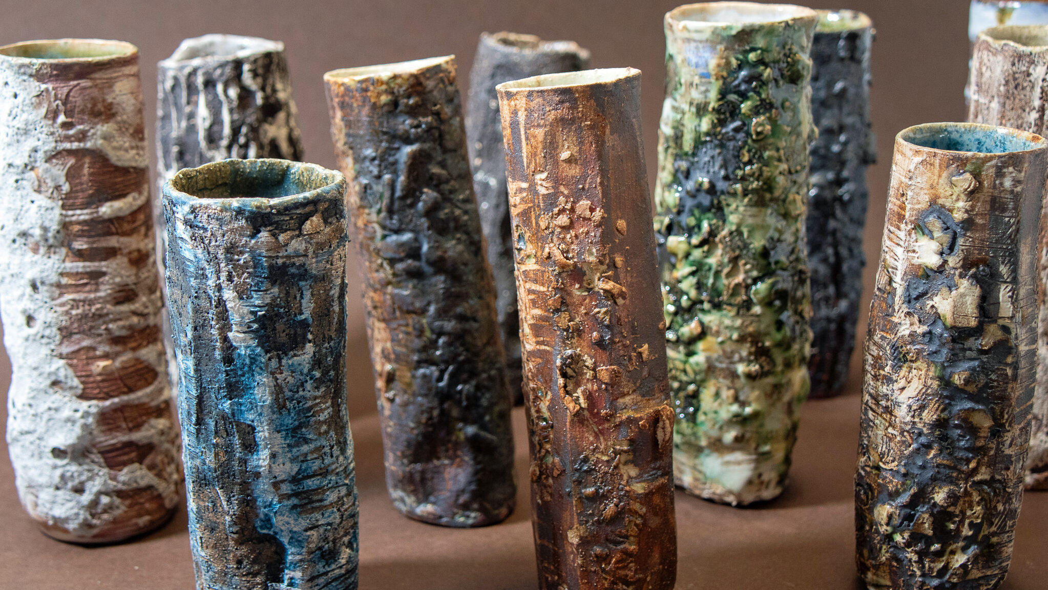 A selection of ceramic work, resembling textured tree trunks
